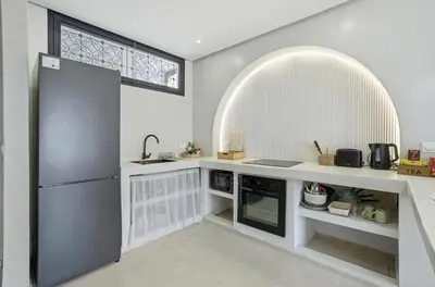 a kitchen with a refrigerator and an arched window at Cosy Modern Apartment Central Gueliz Marrakech in Marrakech