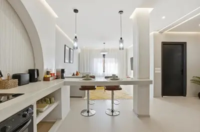 a kitchen with a large white counter and stools at Cosy Modern Apartment Central Gueliz Marrakech in Marrakech