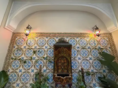 a tiled wall with a clock on it at La Petite Maison by Riad Dar Saad- Dar El Bacha in Marrakech