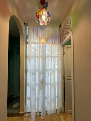 a room with a white curtain and a chandelier at La Petite Maison by Riad Dar Saad- Dar El Bacha in Marrakech