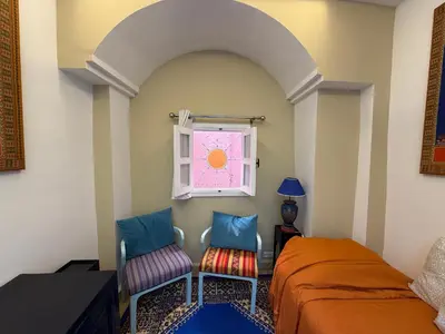 a bedroom with two chairs and a window at La Petite Maison by Riad Dar Saad- Dar El Bacha in Marrakech