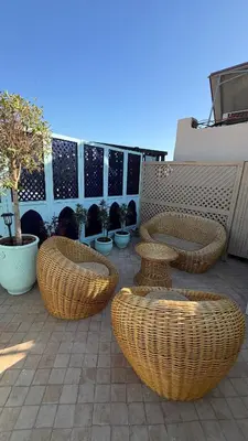 a patio with wicker chairs and tables and potted plants at La Petite Maison by Riad Dar Saad- Dar El Bacha in Marrakech