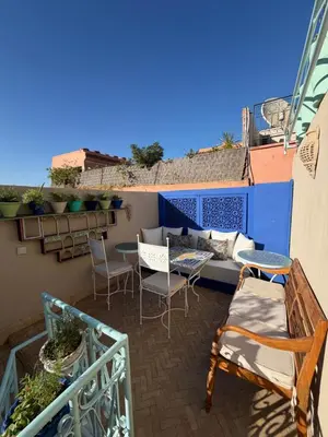 a balcony with a couch and tables and chairs at La Petite Maison by Riad Dar Saad- Dar El Bacha in Marrakech