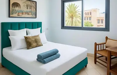 a bedroom with a large bed with a table and a chair at Appartement moderne Guéliz, Centre Marrakech in Marrakech