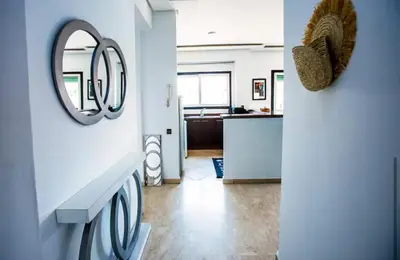 a living room with a mirror and a kitchen at Appartement moderne Guéliz, Centre Marrakech in Marrakech