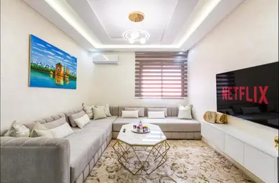 a living room with a couch and a tv at Cosy studio au cœur de Marrakech in Marrakech