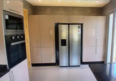 a kitchen with a stainless steel refrigerator and cabinets at Villa Élégance Familiale in Marrakech
