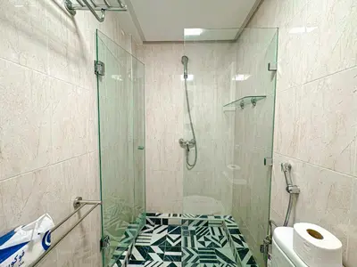 a bathroom with a glass shower with a toilet at Duplex Majorelle avec Jardin et Parking in Marrakech