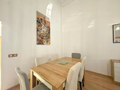 a dining room with a wooden table and chairs at Duplex Majorelle avec Jardin et Parking in Marrakech