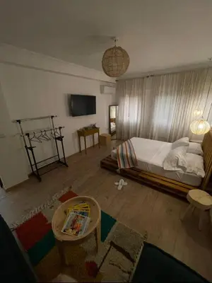 a bedroom with a bed and a table and a tv at Green in majorelle in Marrakech