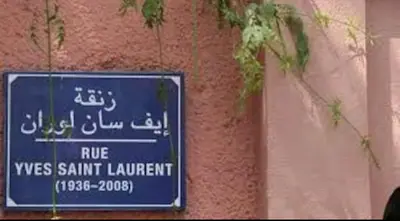 a blue sign on a wall with some plants at Green in majorelle in Marrakech