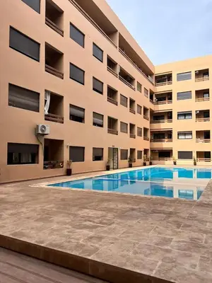 a building with a swimming pool in front of a building at Amazing well located appartement centre of marrakech near medina in Marrakech
