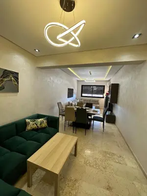a living room with a green couch and a table at Amazing well located appartement centre of marrakech near medina in Marrakech