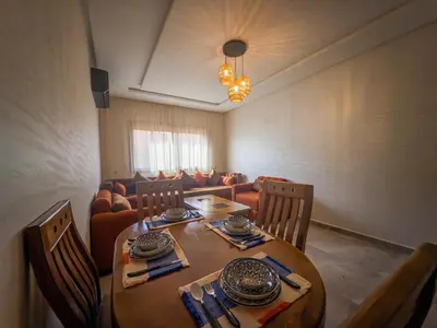 a dining room with a table and a couch at Modern & cozy 2 bedroom apartment in Marrakech