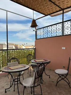 a patio with tables and chairs on a balcony at Riad Le Bijou de Zahra Marrakech Kasbah in Marrakech
