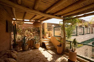 an outdoor patio with potted plants and a pool at Dar Kleta in Marrakech