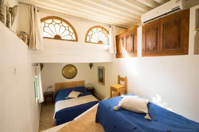 two beds in a bedroom with blue sheets at Dar Kleta in Marrakech