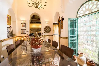 a dining room with a glass table and a chandelier at Dar Kleta in Marrakech