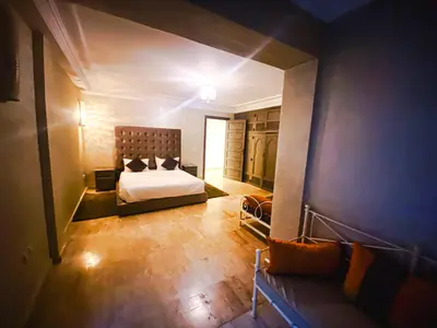 a view of a bedroom with a bed and a couch at Villa Moyen orient by séjour in Marrakech