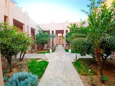 a courtyard of a building with trees and a fountain at Villa Moyen orient by séjour in Marrakech