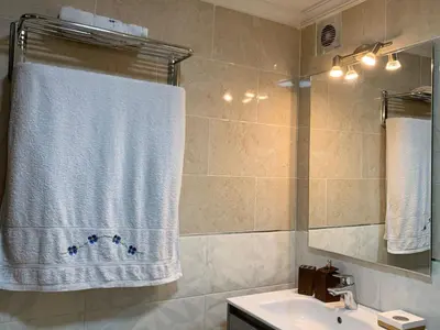 a bathroom with a white shower curtain and a sink at Appartements du luxe in Marrakech