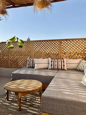 a room with two beds and a bench and a table at Dar Chiba Medina in Marrakech