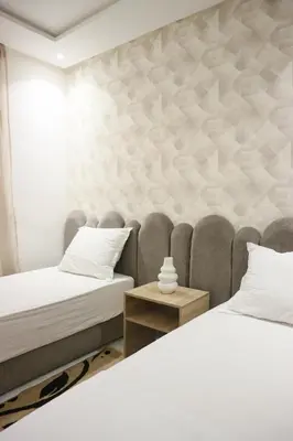 two beds in a room with a wall mural at Central B1 Chic & Shock , hivernage city center in Marrakech