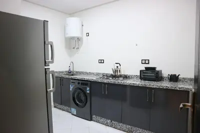a kitchen with black cabinets and a washer and dryer at Central B1 Chic & Shock , hivernage city center in Marrakech