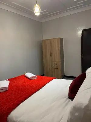 a bedroom with a large bed with red and white sheets at MarrakLuft in Marrakech