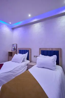 two beds sitting next to each other in a room at Appartement l'aéroport in Marrakech
