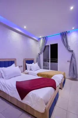 a bedroom with two beds and a window at Appartement l'aéroport in Marrakech