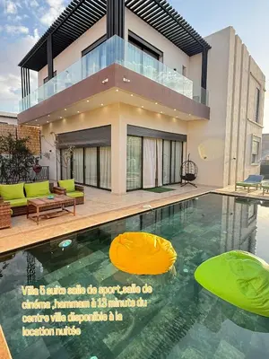 a house with a swimming pool in front of a house at Villa luxueuse in Marrakech
