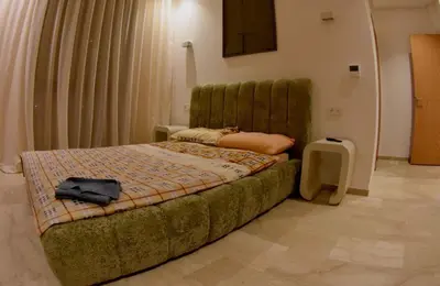 a bedroom with a green bed with a black bag on it at Villa luxueuse in Marrakech