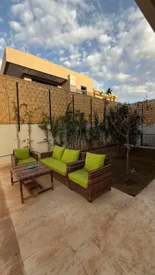 a couch with green cushions sitting on a patio at Villa luxueuse in Marrakech