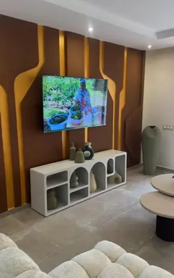 a living room with a flat screen tv on a wall at Bel appartement neuf in Marrakech