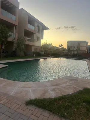a swimming pool in front of a apartment building at Bel appartement neuf in Marrakech