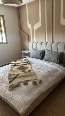a bed with a blanket on it in a room at Bel appartement neuf in Marrakech
