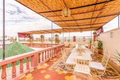 a patio with tables and chairs on a balcony at Emerald palace in Marrakech