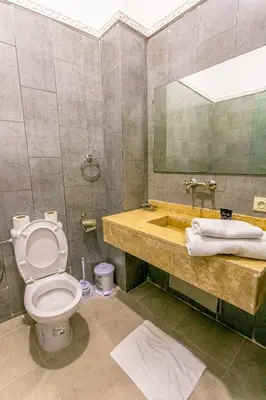 a bathroom with a toilet and a sink with a mirror at Emerald palace in Marrakech