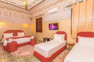 a room with two beds and two chairs in it at Emerald palace in Marrakech