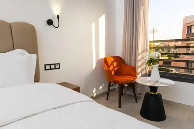 a hotel room with a bed and a chair and a table at The Pearl Loft, Marrakech Luxury Apartment in Marrakech