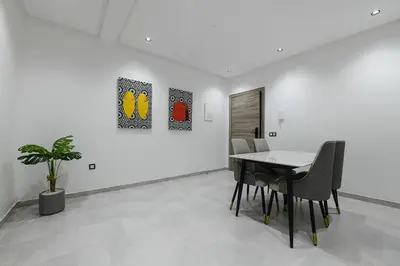 a dining room with a table and chairs and two paintings at The Pearl Loft, Marrakech Luxury Apartment in Marrakech