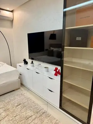 a living room with a television and a white cabinet at Modern charm in Marrakesh for a relaxing stay in Marrakech