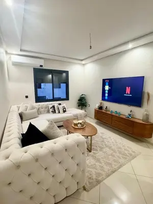 a living room with a white couch and a large tv at Modern charm in Marrakesh for a relaxing stay in Marrakech