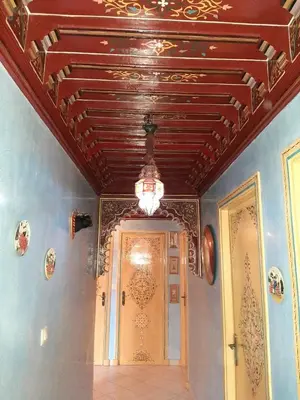 a hallway with a door and a chandelier on the ceiling at Appartement centre de Marrakech in Marrakech