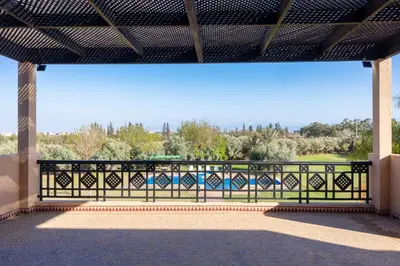 a balcony with a fence and a view of a park at Villa Dar Zitoune in Marrakech