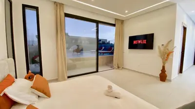 a living room with a bed and a tv at Villa de Rêve sans vis-à-vis à Marrakech in Marrakech