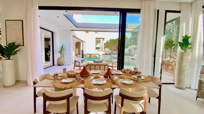 a dining room with a wooden table and chairs at Villa de Rêve sans vis-à-vis à Marrakech in Marrakech