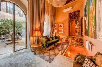 a living room with a green couch and a window at Riad Royal Koubba in Marrakech