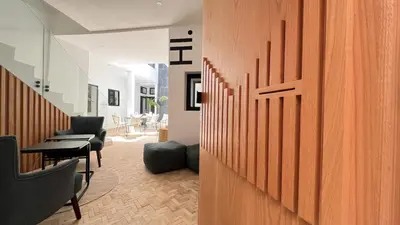 a room with a wooden wall with a table and chairs at Riad Manoury Marrakech - privates Boutique-Hotel für 6 in Marrakech